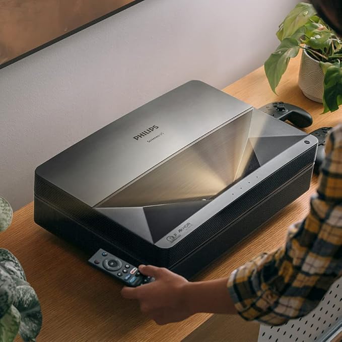 Philips projector on a table with a person holding a remote control | Philips Screeneo U5 Home Projector | Ultra Short Throw | Black | Connect It Ireland